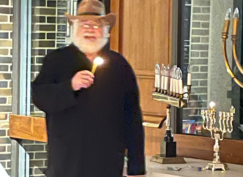 Rabbi Jacob Rosner of Congregation Agudas Israel lights the Menorah, Sunday night, on the first night of Hanukkah. The congregation will also host outdoor lightings every night at 6 p.m. (except Friday, which will be at 4 p.m.) and honor a different community group each night.